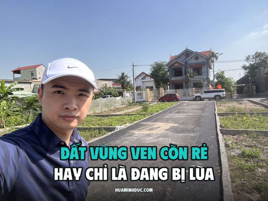 Hứa Minh Đức đội mũ trắng đứng đầu con đường bê tông mới đổ chạy giữa các lô đất nền vùng ven, phía sau là nhà dân và ô tô đỗ ven đường, kèm dòng chữ Đất vùng ven còn rẻ hay chỉ là đang bị lùa