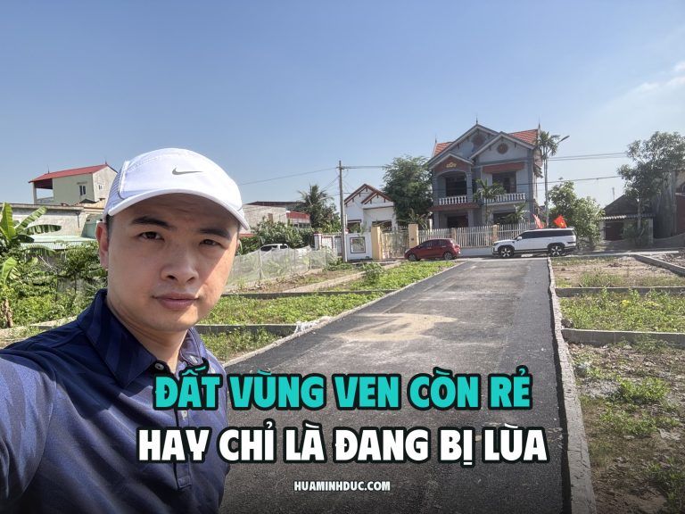 Hứa Minh Đức đội mũ trắng đứng đầu con đường bê tông mới đổ chạy giữa các lô đất nền vùng ven, phía sau là nhà dân và ô tô đỗ ven đường, kèm dòng chữ Đất vùng ven còn rẻ hay chỉ là đang bị lùa