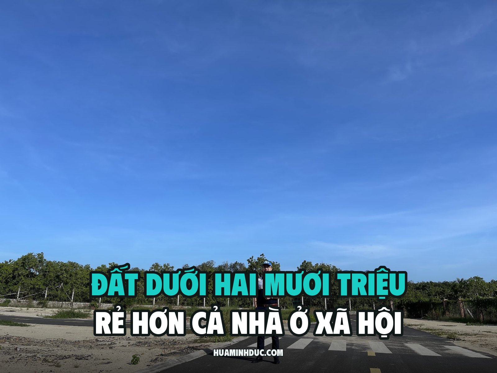 Hứa Minh Đức đứng trên tuyến đường nhựa mới trải, kẻ vạch sơn còn nguyên, hai bên là các lô đất trống chưa xây, kèm dòng chữ Đất dưới hai mươi triệu rẻ hơn cả nhà ở xã hội
